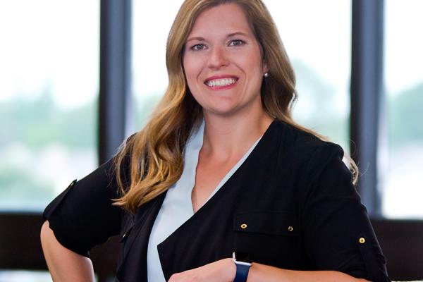 Anna Workman, posing by leaning with one elbow on a green chair.